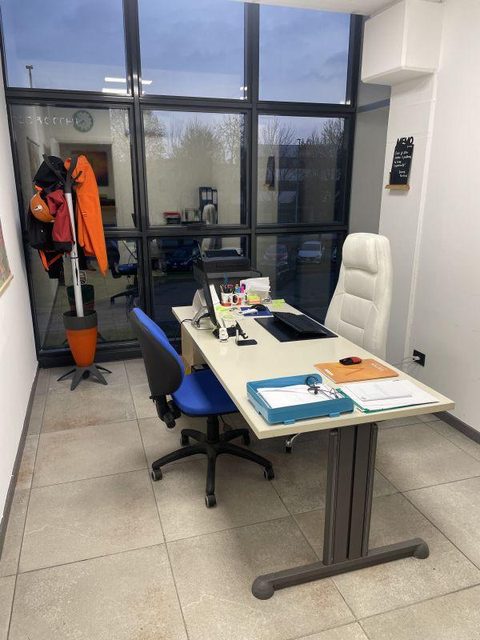 Postazione di lavoro con giacche da lavoro appese nella sede di Biassono